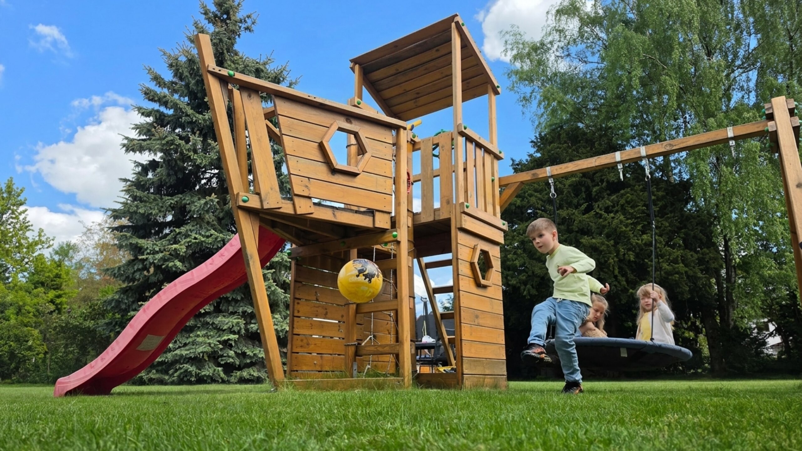 Spielturm aus Massivholz im Garten.