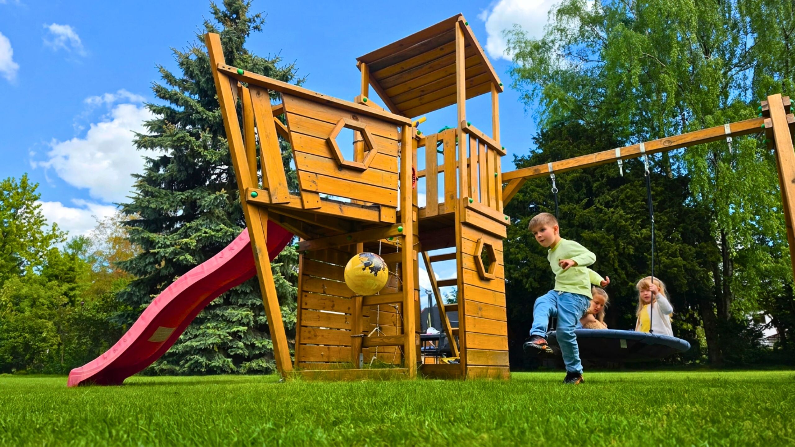 Spielturm aus Massivholz im Garten.